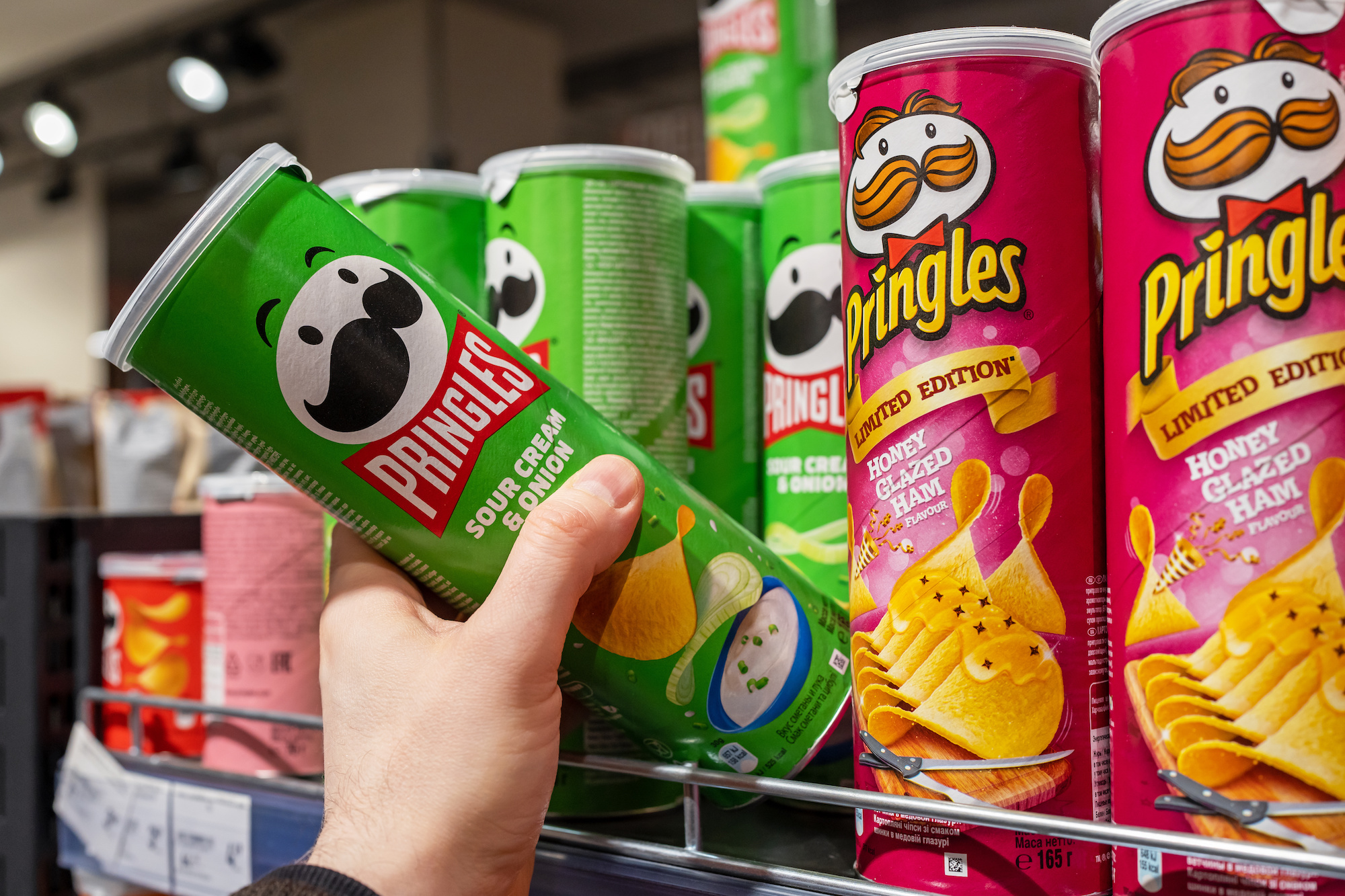 hand taking Pringles can off the shelf